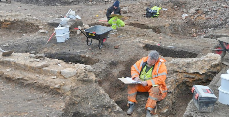 Recording the northern end of the Roman buildings. Note that the gap in the wall is made by a later ditch and medieval pit cutting through the walls and removing the stone
