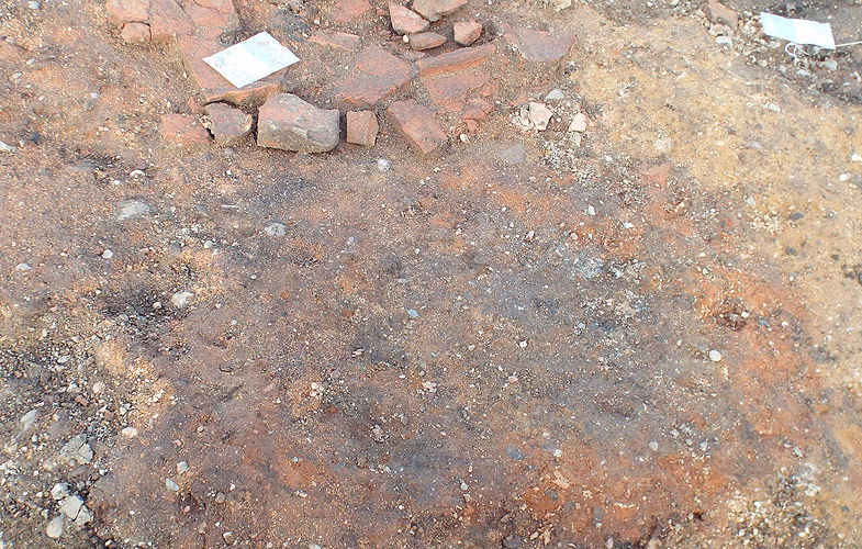 The orange colour indicates that some kind of heating has occurred, probably indicating a hearth or similar feature