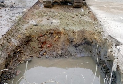 Trench with contaminated water and reinforced concrete slab